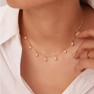 18K gold plated titanium necklace featuring seven elegant small pearls on a model
