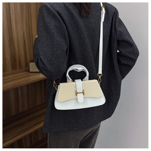 Detail showing the contrast stitching, woven flap, and golden H-clasp on this crossbody bag