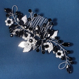 Detail of bridal hair comb featuring black crystals and white pearls on silver leaves