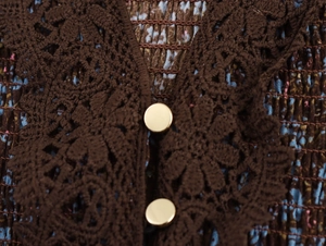 Detail of floral chiffon dress with hollow lace trim and golden round buttons
