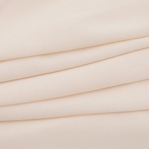 Macro shot of light beige chiffon fabric texture showing soft pleats and fine fiber weave