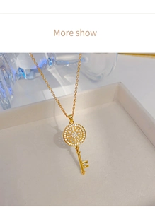 Detail shot of a golden magic key pendant necklace with sparkling zircon inlay stones
