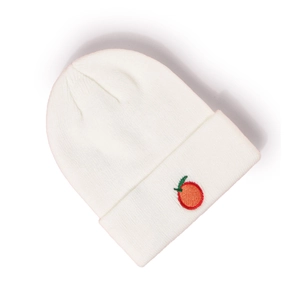 Détail du bonnet en maille côtelée blanche avec broderie de fruit orange sur le revers