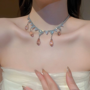 Detail of zircon teardrop tassel necklace on model neck in French vintage style