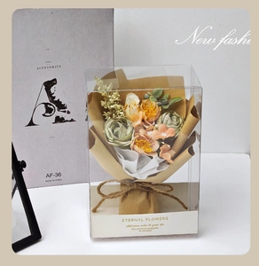 Mini artificial rose bouquet in transparent acrylic gift box with twine ribbon and kraft paper