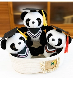 Group of graduation panda plush toys in a basket with doctor caps.