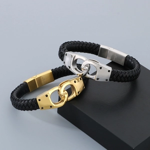 Detail of woven leather bracelets with magnetic handcuff clasp in gold and silver finish