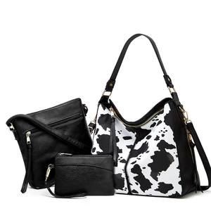 Three-piece set including cow print tote bag, black crossbody, and small coin purse with gold zipper