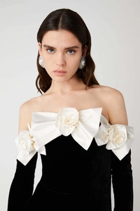 Detail of off-shoulder evening dress with large white satin roses and pearl accents
