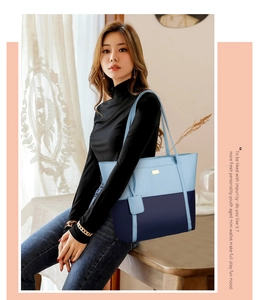Blue two-tone faux leather tote bag carried by model in a soft indoor setting