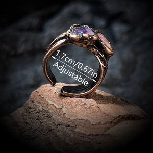 Vintage adjustable bronze ring with raw amethyst and quartz stones on rock background
