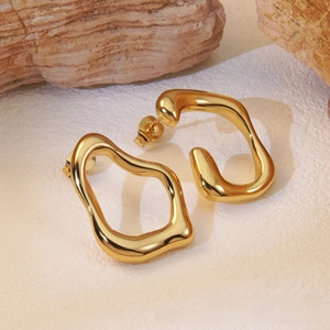 Close-up of French vintage irregular gold earrings on natural stone background