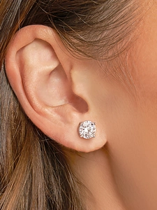 Macro view of a classic round cut moissanite stud earring in 925 sterling silver on ear