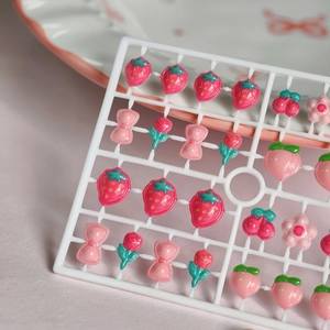 Breloques nail art en résine avec motifs fraise et pêche mignons sur support blanc