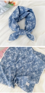 Detail of blue floral cotton scarf with white lace edges and delicate embroidery