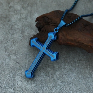Close-up of blue stainless steel cross pendant featuring engraved Lord's Prayer text