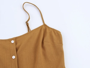 Détail d'un caraco brodé marron en coton avec fines bretelles et boutons blancs