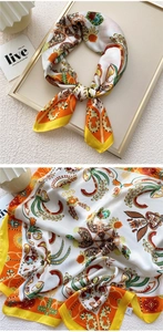 Detailed close-up of an orange paisley silk scarf draped inside a golden picture frame