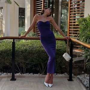 Detailed view of backless purple pleated maxi dress on a model in an outdoor setting