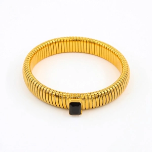 Detail of golden Tubogas snake bracelet featuring a rectangular black zircon gemstone