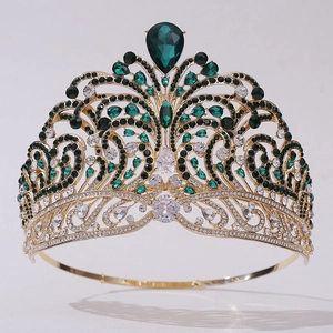 Close-up of golden crown with green pear-shaped gemstones and sparkling crystals