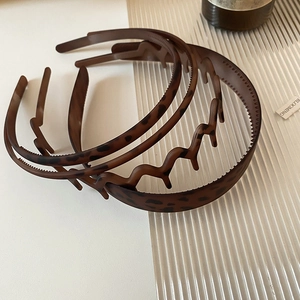 Detail of vintage amber leopard print headbands set on a modern fluted glass background