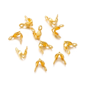 Macro view of gold-plated stainless steel fold-over jewelry crimp covers for DIY crafts