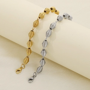 Detailed view of spiral spring bead chains in polished gold and silver stainless steel
