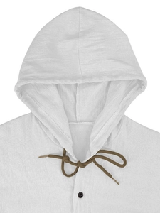 Detail of white linen hooded shirt showing drawstring textures and fabric weave