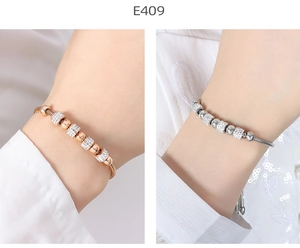 Macro detail of gold and silver snake chain bracelets with sparkling zircon crystal rings