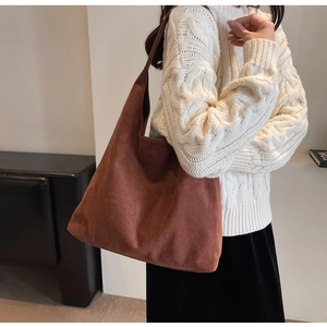 Brown suede tote bag shown on model with white knit sweater for autumn style