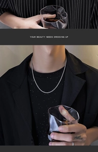 Detail of silver dragon bone chain necklace shown with an elegant lifestyle model shot