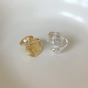 Detailed view of textured gold and silver open rings with organic crinkle patterns