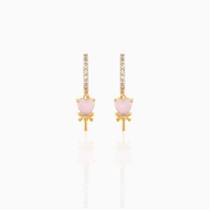 Macro detail of gold-plated heart lollipop earrings with pavé zircons and bow accent