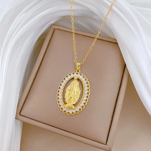 Macro shot of gold oval pendant with Virgin Mary relief and sparkling crystals