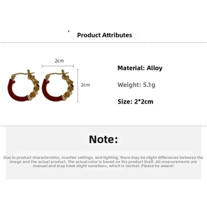 Détail de boucles d'oreilles créoles en émail rouge et relief doré, taille 2x2cm