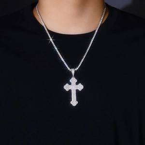Macro shot of silver hip-hop cross pendant set with sparkling moissanite on a tennis chain