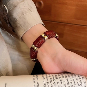 Detail of red glitter resin geometric beads and gold metal spacers on a vintage bracelet