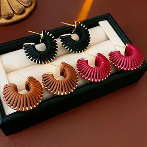 Three pairs of faux leather threaded C-shaped hoop earrings in black, pink, and tan colors