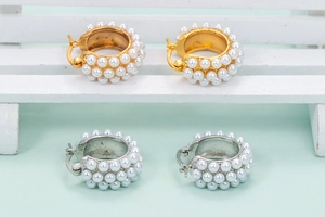 Detail of vintage-style hoop earrings with multi-layered white pearls in gold and silver