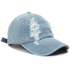 Close-up of distressed light blue denim baseball cap with vintage frayed edges and texture