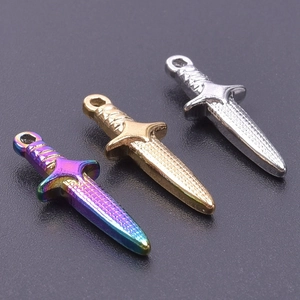 Vista dettagliata di tre ciondoli a spada in finitura arcobaleno, oro e argento per DIY
