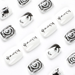 Artistic black and white press-on nails with manga eyes and spiral patterns