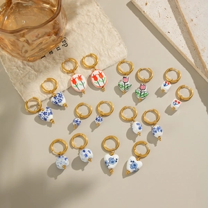 Vintage gold hoop earrings with handmade ceramic floral pendants in elegant retro style