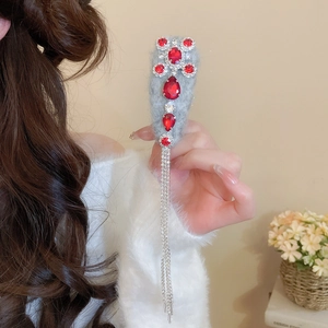 Detail of red rhinestone tassel hair clip with plush base and shimmering crystal fringes