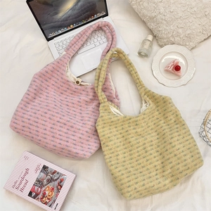 Detailed view of colorful plush tote bags with soft textured fabric on a white bed
