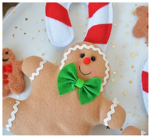 Close-up of a plush gingerbread man ornament with festive ribbons and star decorations