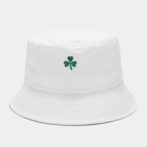 Détail de la broderie trèfle vert sur un chapeau bob blanc en coton pur