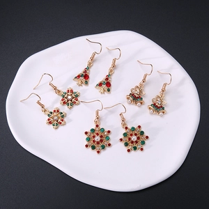 Christmas earring set with golden bells, trees and snowflakes on white tray