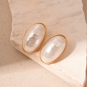 Elegant vintage oval pearl stud earrings with gold plating on natural stone background